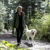 Lady with a dog walking down a trail