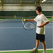 boy serving tennis ball