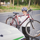 Lady placing bike on bus bike rack