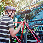 Man putting bike on veh bike rack