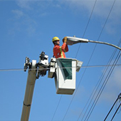 Worker in bucket fixing street light