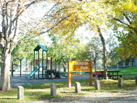 Lochside Park playground and park sign with trees in the forefront