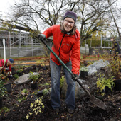 Volunteer holding a shovel while working in a natural area of Glanford Park