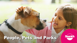 Young girl petting a dog wearing a collar and leash