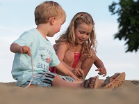 Two young kids having fun at the beach in Cadboro-Gyro Park